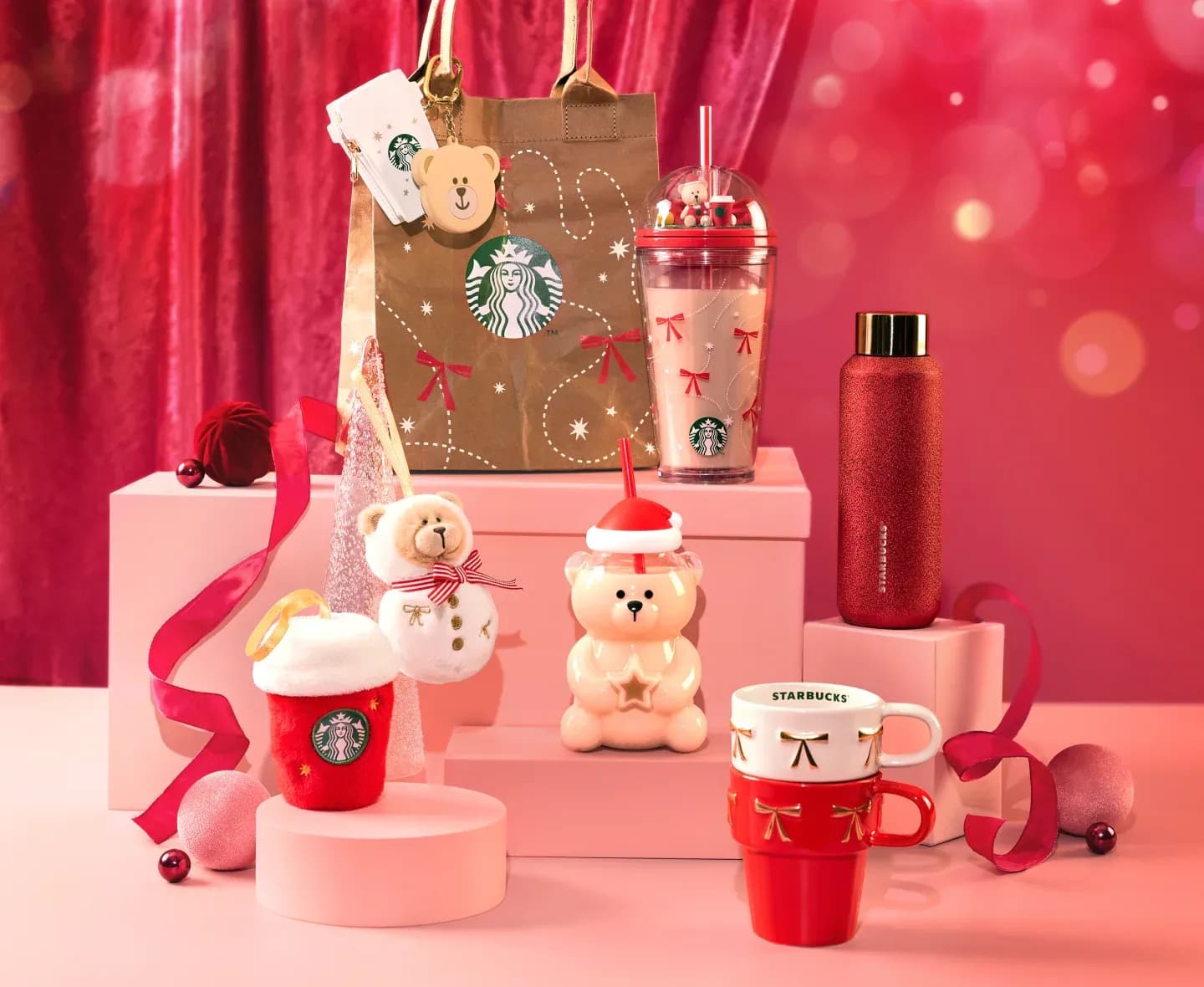 Starbucks Japan Holiday 2026 goods: the glass Bearista tumbler in a Santa hat lid, a red glitter bottle, stacking mugs with ribbons, plush ornaments and a craft paper shopper