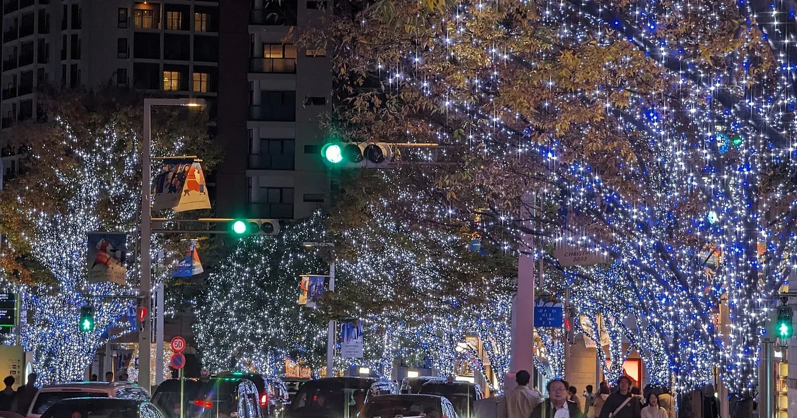 Roppongi Keyakizaka avenue lit in white and blue with Tokyo Tower at the end of the street, November 2023